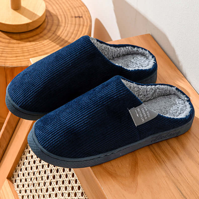 Home Indoor Wear-resistant Non Slip Cotton Slippers in navy blue with soft grey inner lining on wooden surface.